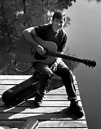 Photo playing guitar by window